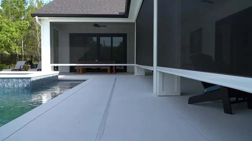 SunPro motorized screens lowered around a poolside lanai with lounge seating and a covered patio.